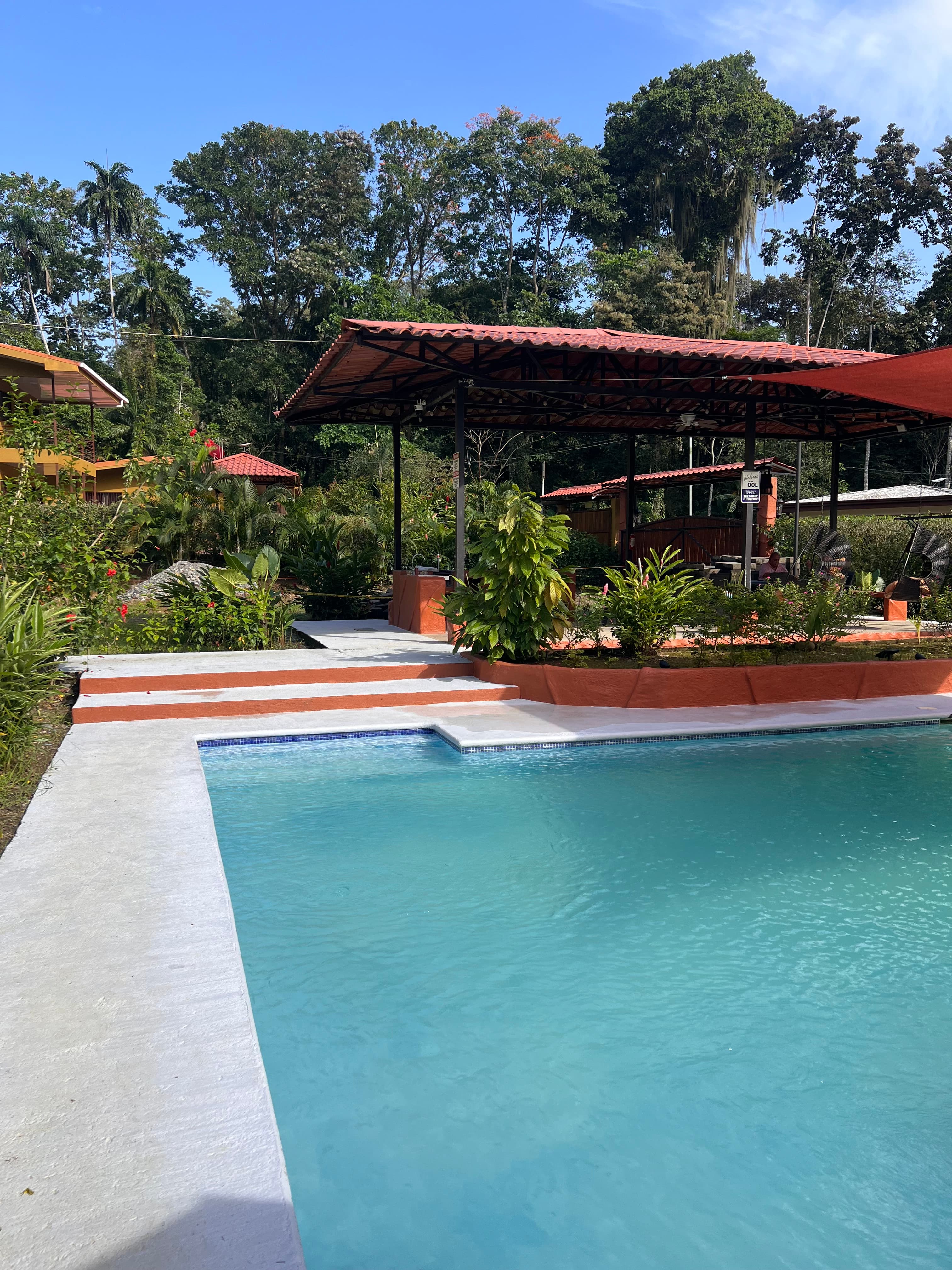 The pool in daylight with the rancho at its far end
